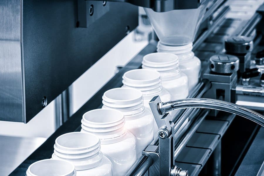 Bottles being filled with medications on a assembly line